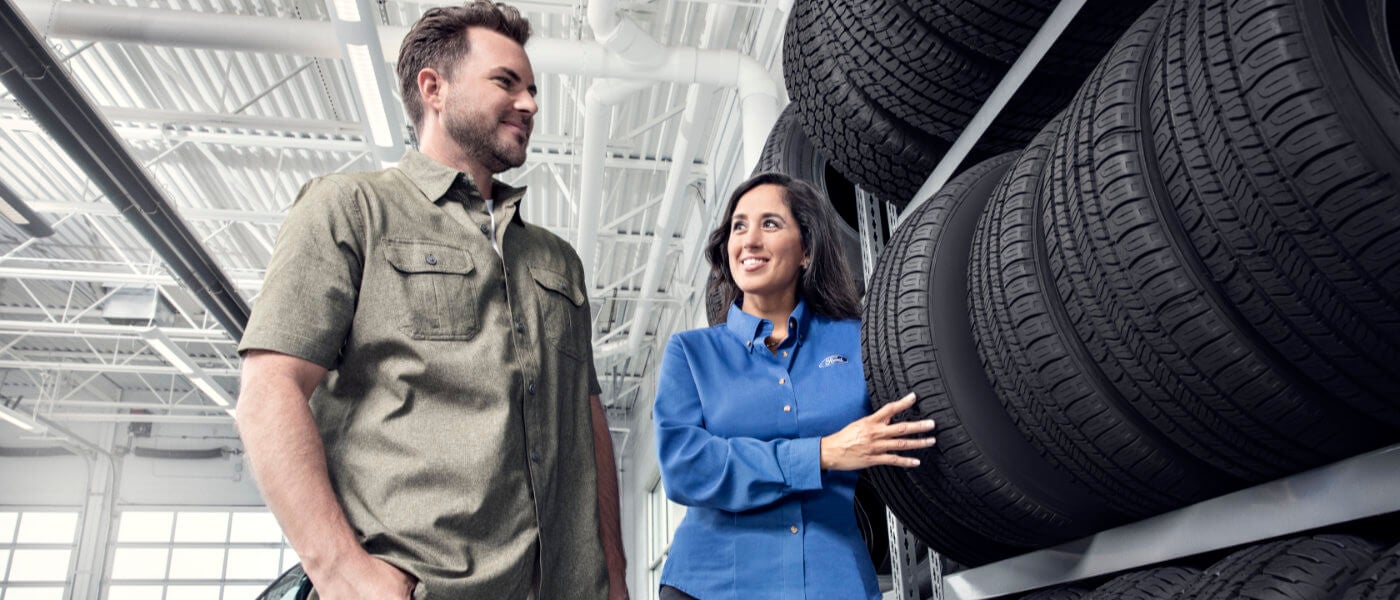 Salesperson showing customer tires